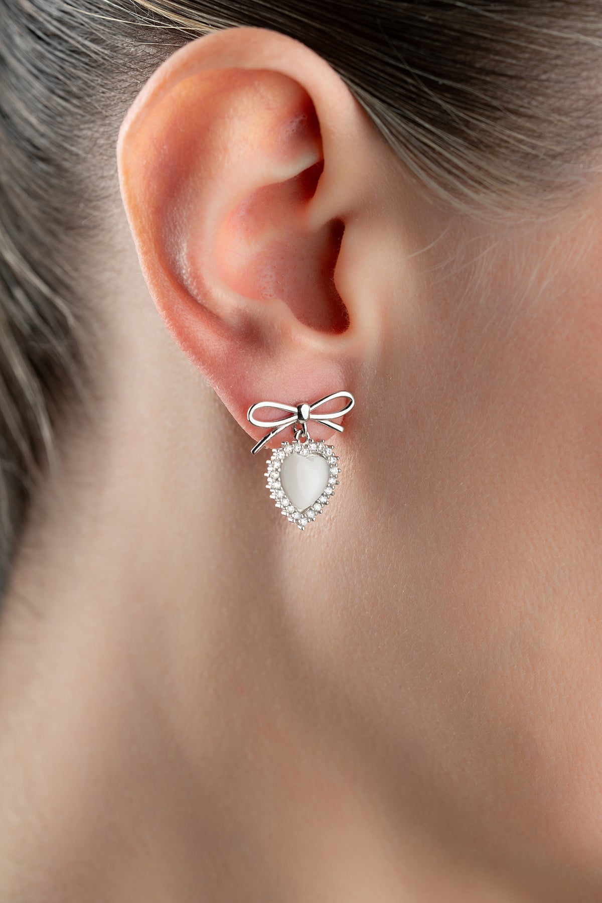 Silver earrings with heart and bow detail