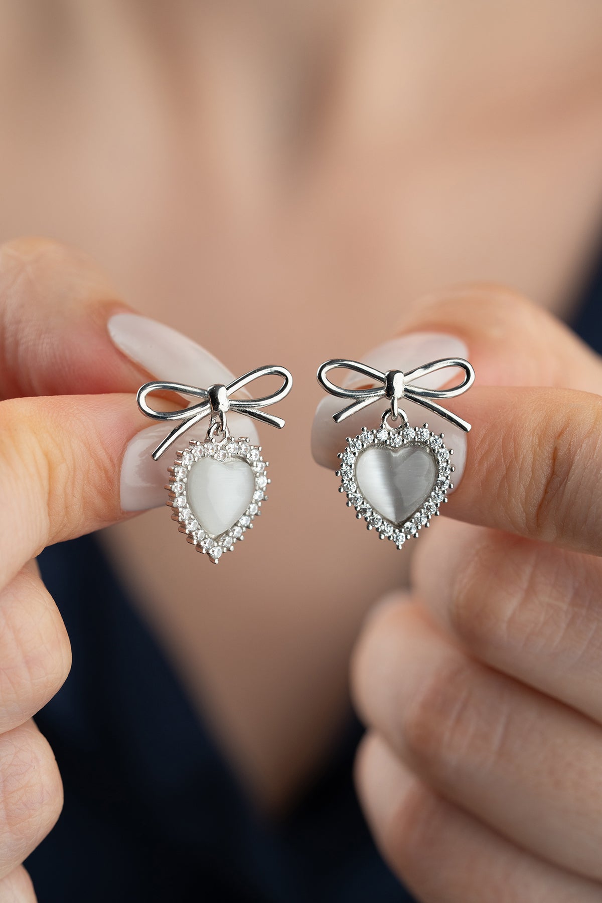 Silver earrings with heart and bow detail