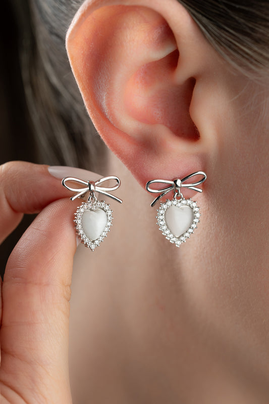 Silver earrings with heart and bow detail