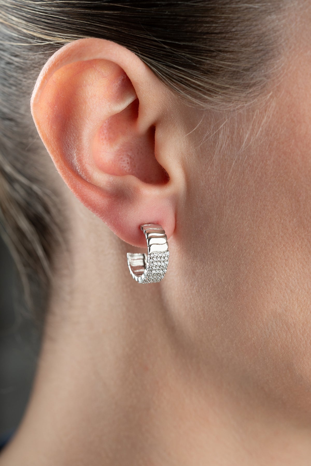 Silver -colored ribbed earrings with zircon stones