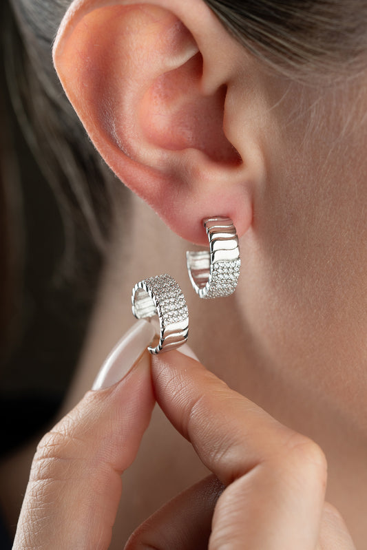 Silver -colored ribbed earrings with zircon stones