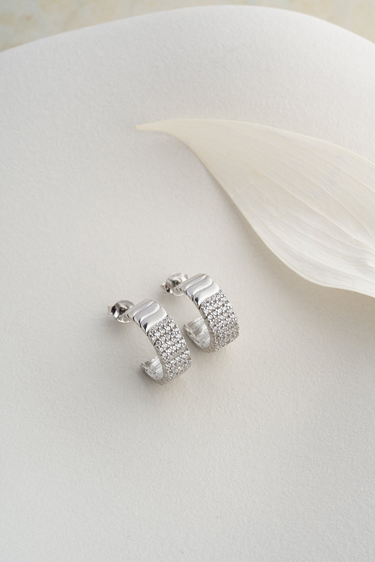 Silver -colored ribbed earrings with zircon stones