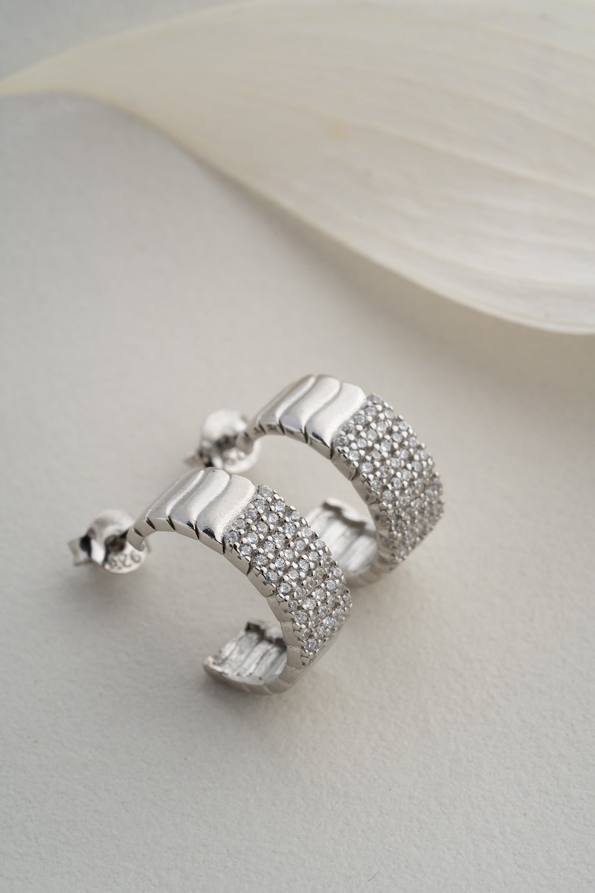Silver -colored ribbed earrings with zircon stones
