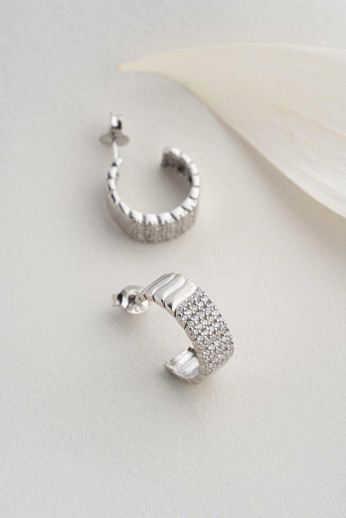 Silver -colored ribbed earrings with zircon stones